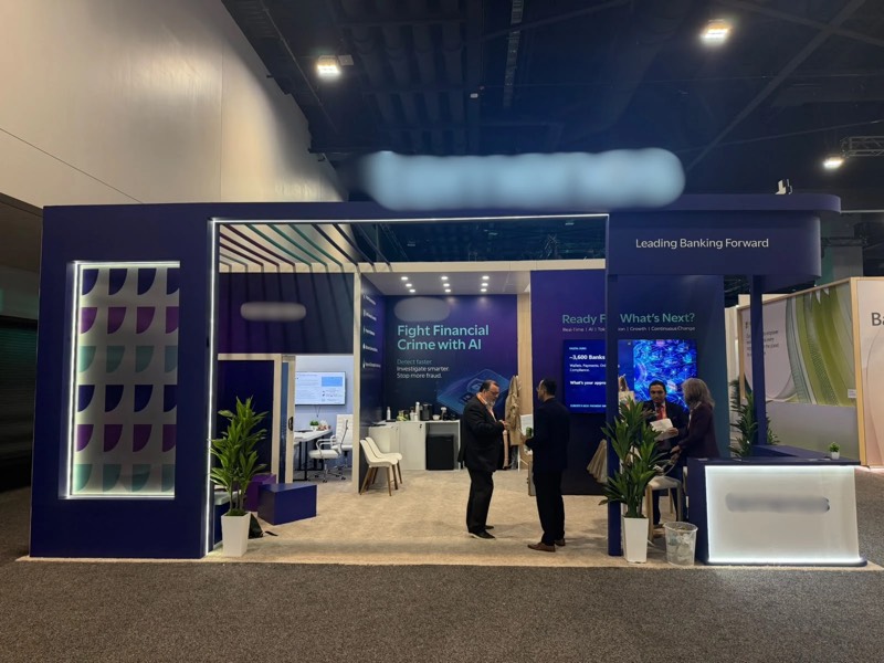 Navy blue custom exhibition stand with an LED-framed portal and lounge area at SIBOS 2026, Miami Beach Convention Center